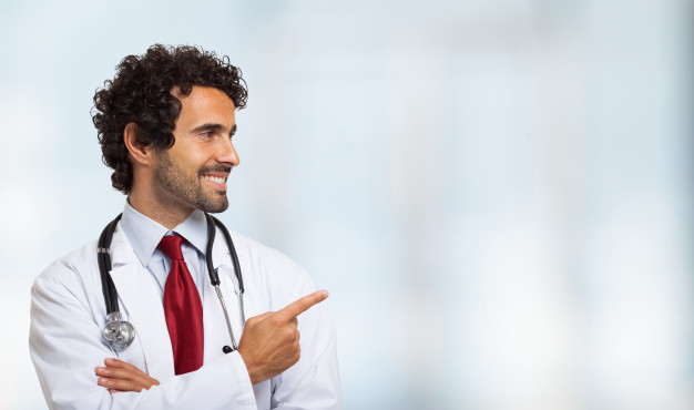 Retrato de um médico sorridente apontando o dedo | Foto Premium