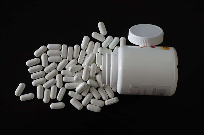 Medication capsules beside container